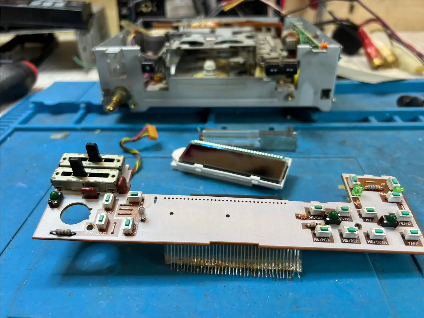 Alpine 7292MS faceplate disassembled – main button PCB and display module removed on the bench for backlight bulb replacement and cleaning.