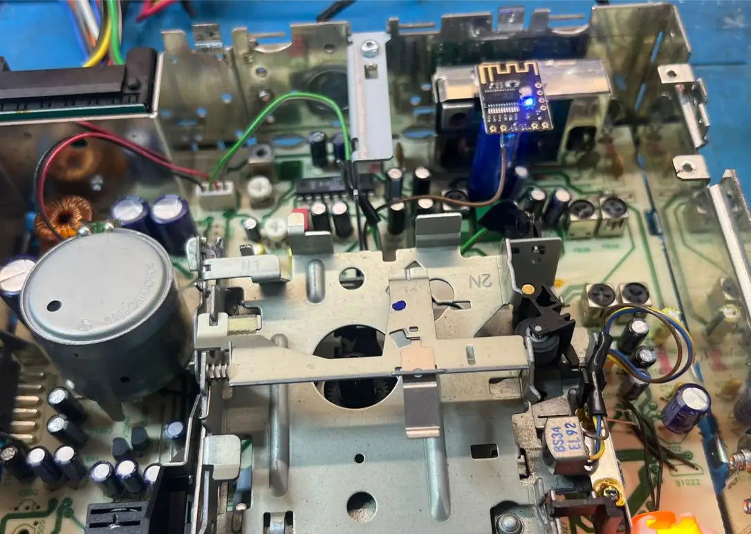 Internal Bluetooth retrofit installation inside vintage cassette car radio showing integrated wireless module on circuit board