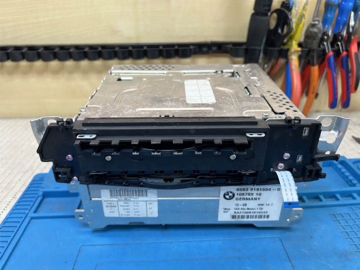 BMW E-series CCC head unit on the workshop bench before repair