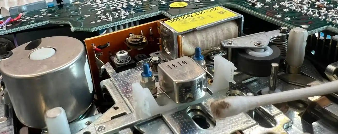 Cassette deck mechanism with motor, solenoids and tape transport assembly visible
