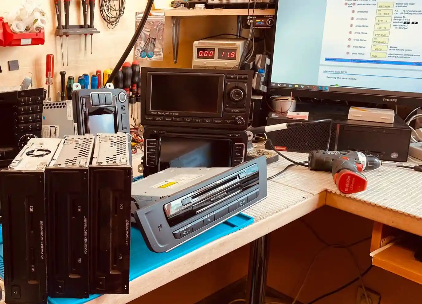 VW, Audi, Škoda and SEAT Harman MMI navigation units on workbench prepared for diagnostics and electronic repair